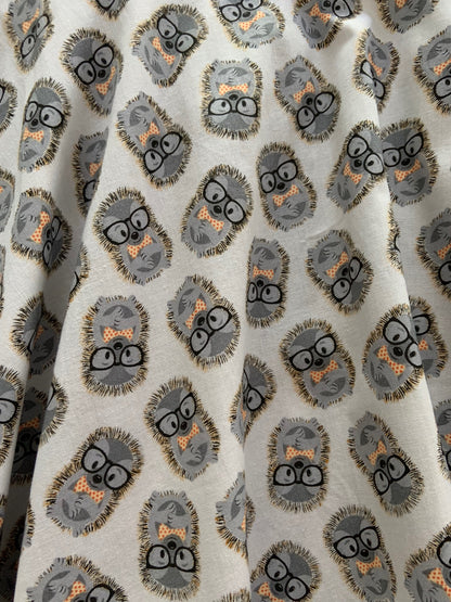 a close up of the fabric print showing the tossed hedghogs with glasses and bow ties