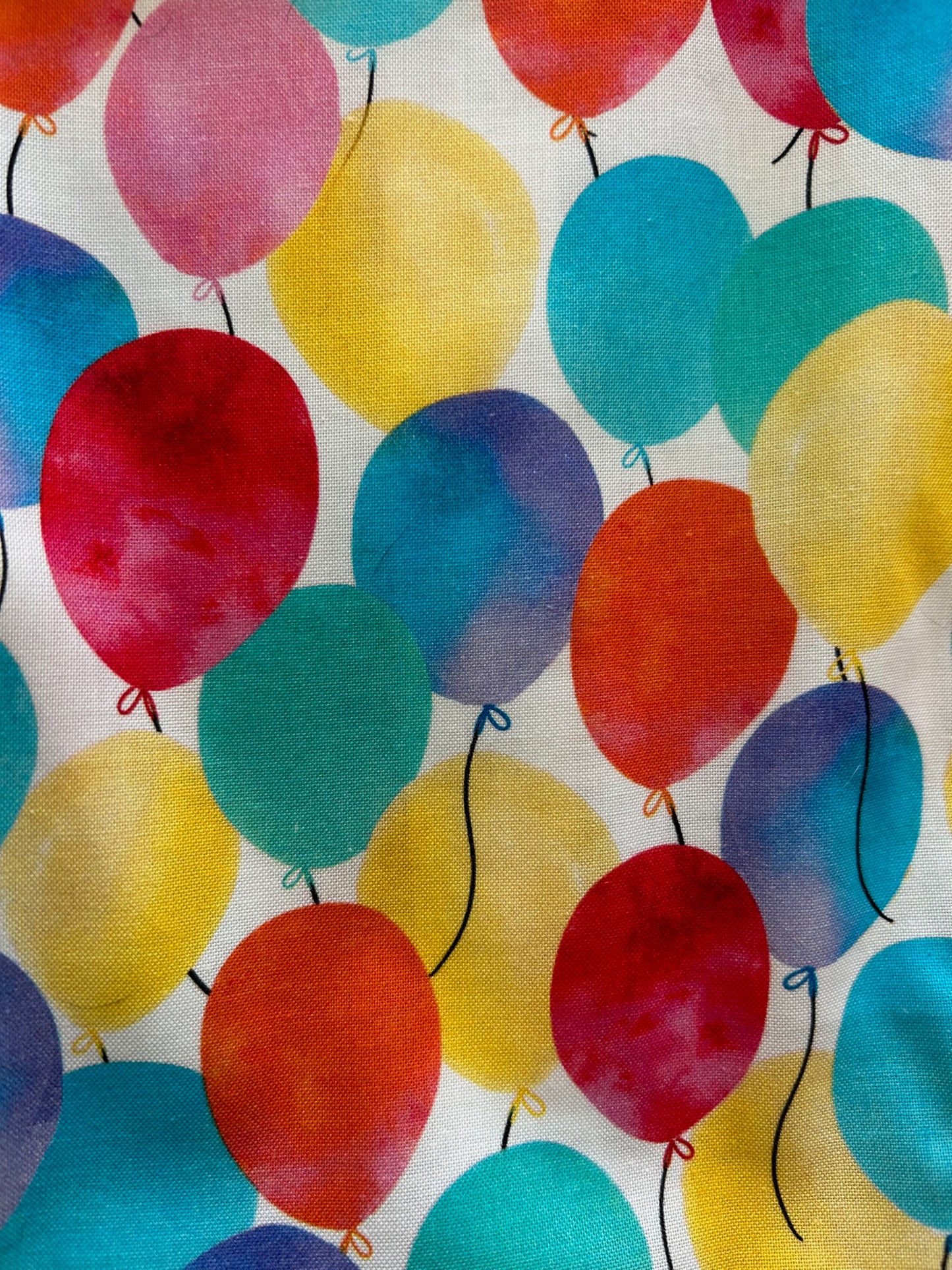 a close up of the fabric of balloons fit & flare dress showing colorful balloons on white background