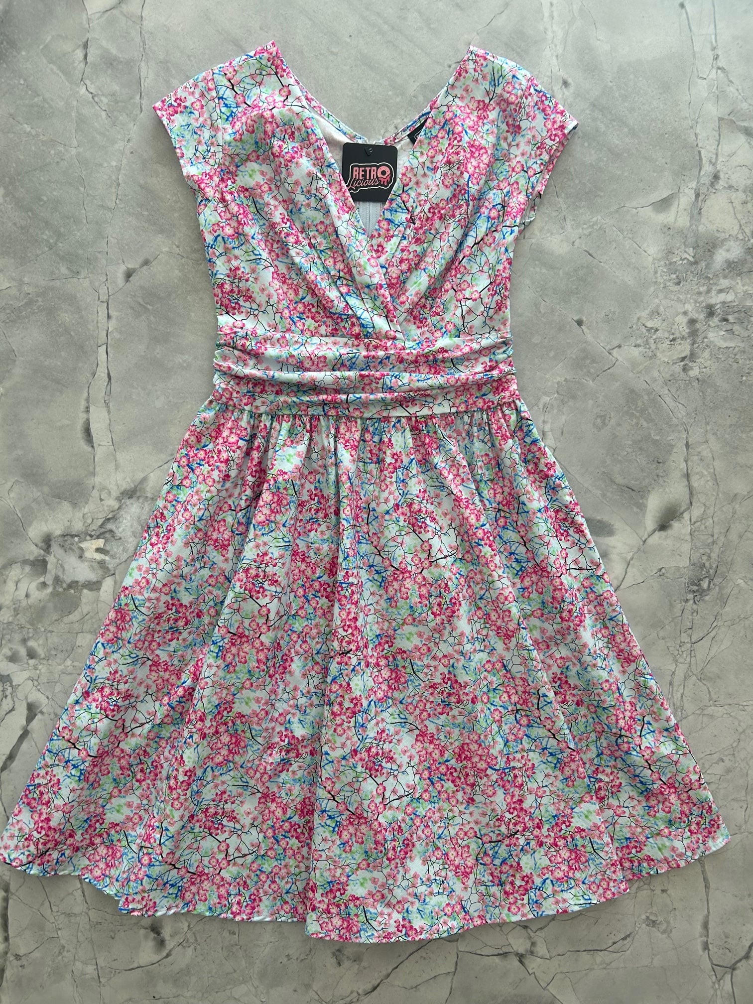 a flat lay of the front of the cherry blossom greta dress
