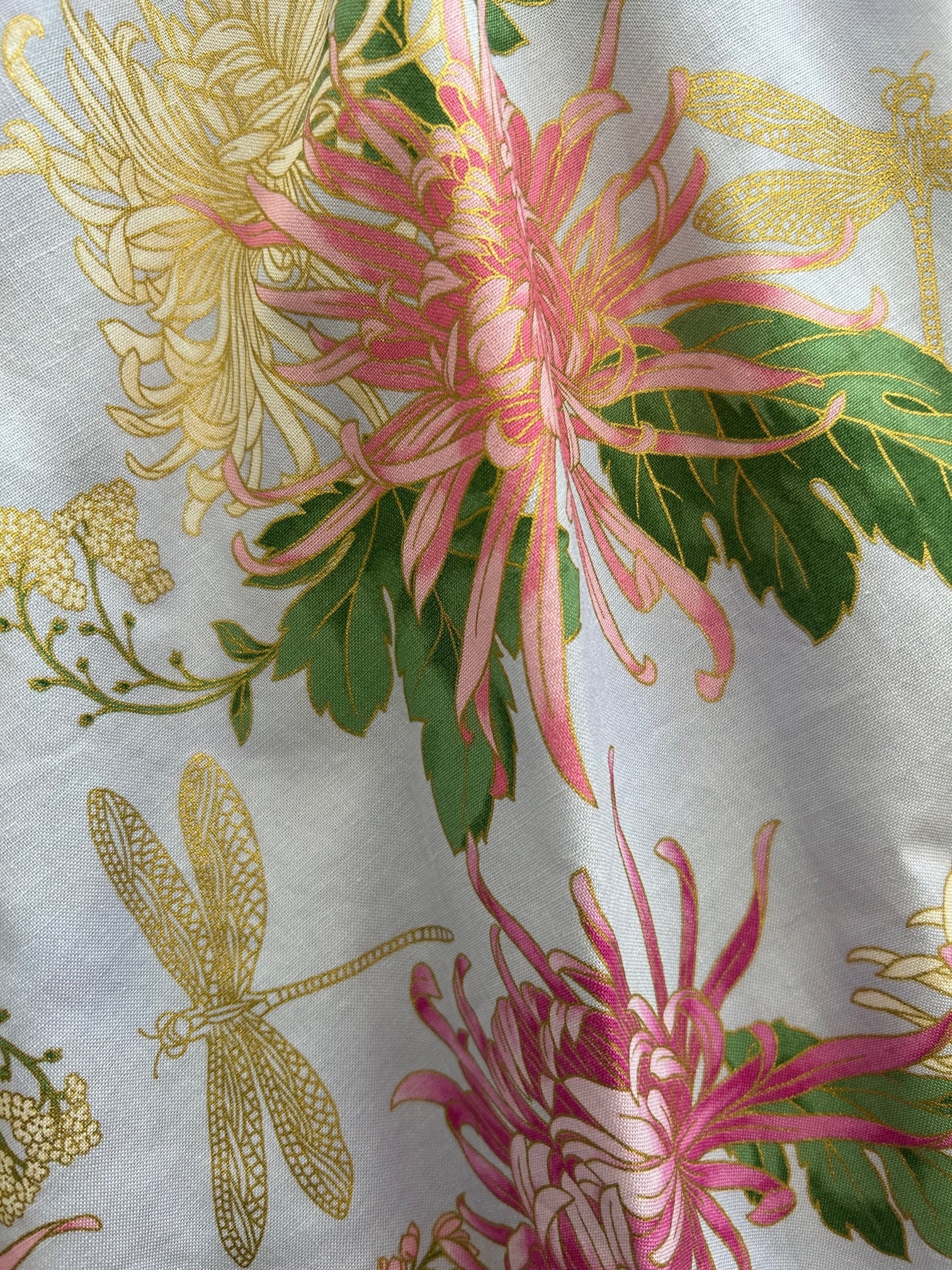 a close up of the fabric showing gold metallic details and gold metallic dragonflies