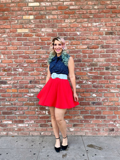 a full length of a model standing in front of a brick wall wearing our STEM bow top