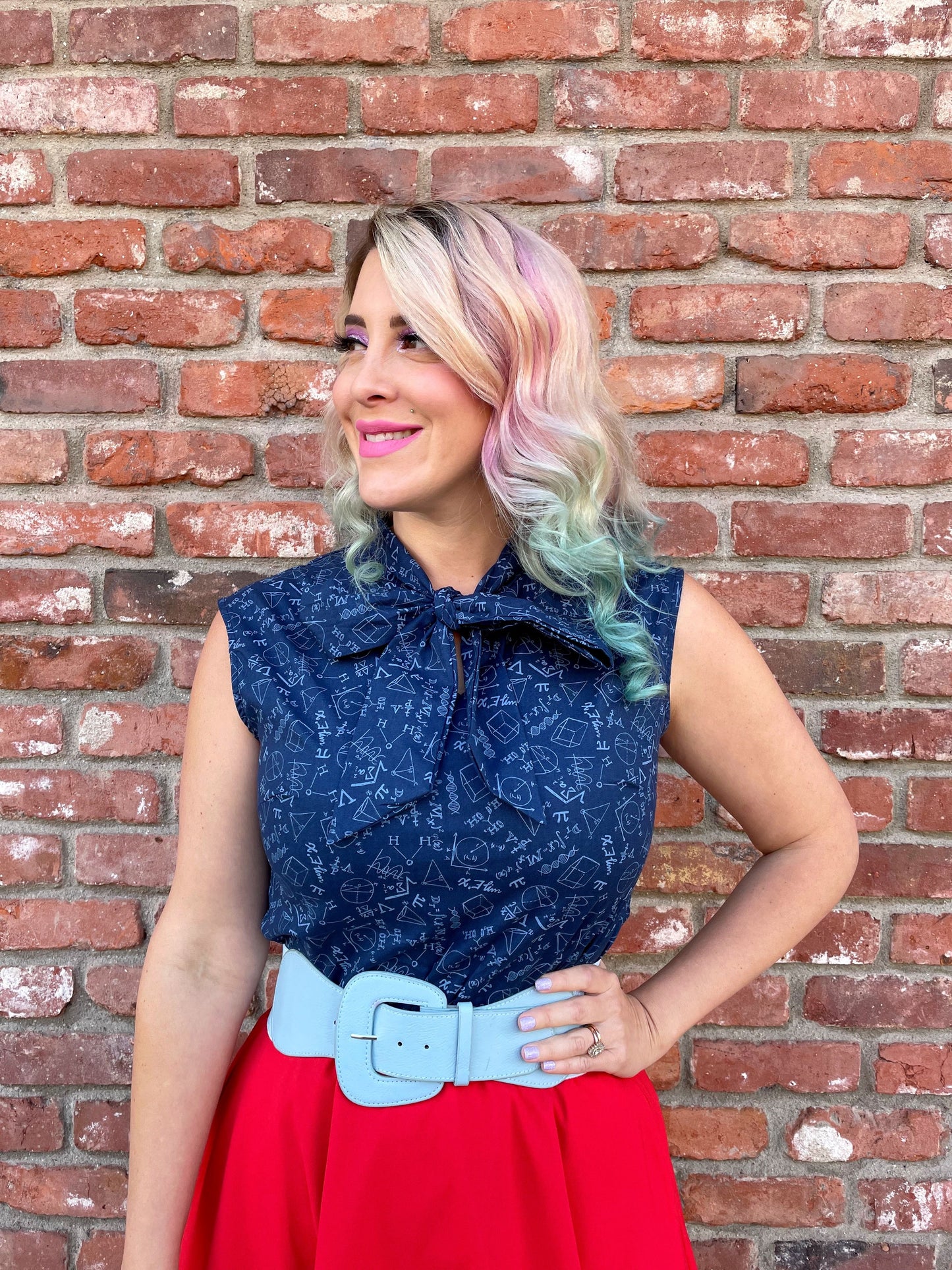 a close up of a model standing in front of a brick wall wearing our STEM bow top