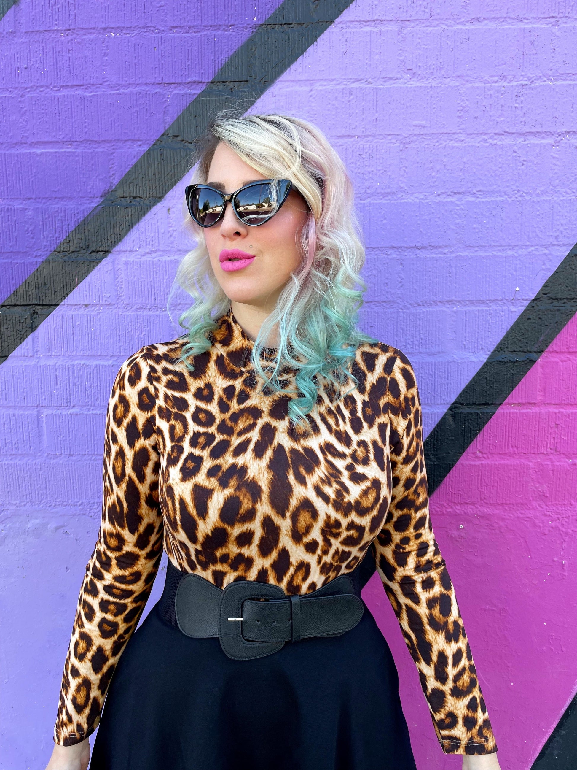 a close up of a model wearing our leopard mock neck top