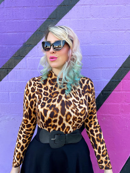 a close up of a model wearing our leopard mock neck top