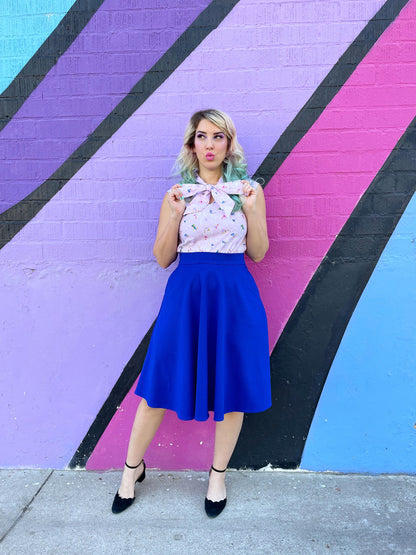 a model standing in front of a painted wall wearing a charlotte skirt in royal blue 