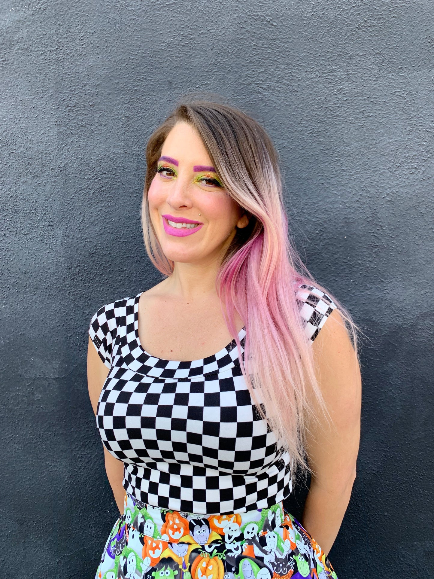 close up of model standing in front of a black wall wearing our boat neck top in checkers