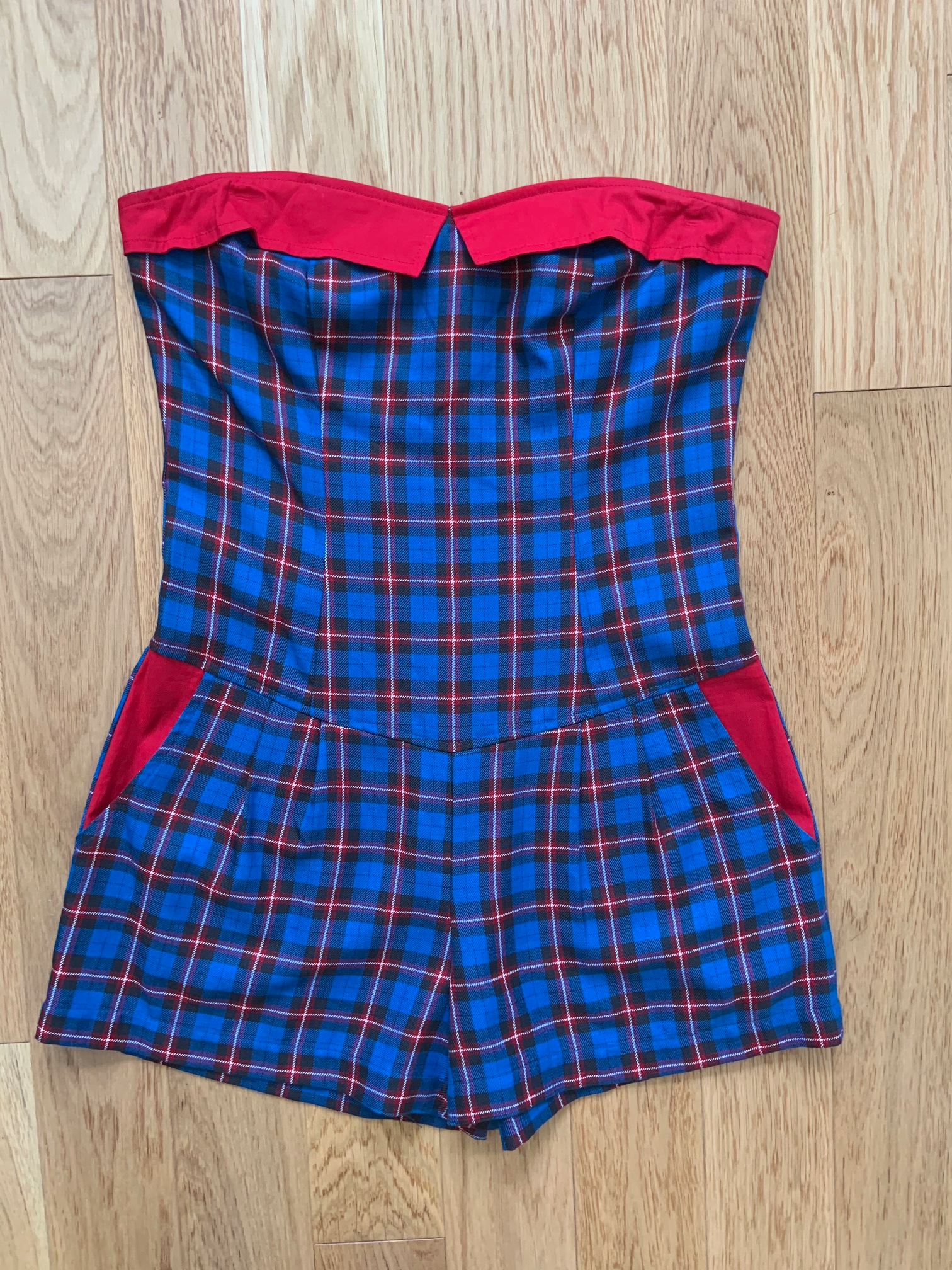 a flat lay of blue plaid romper with red contrast 