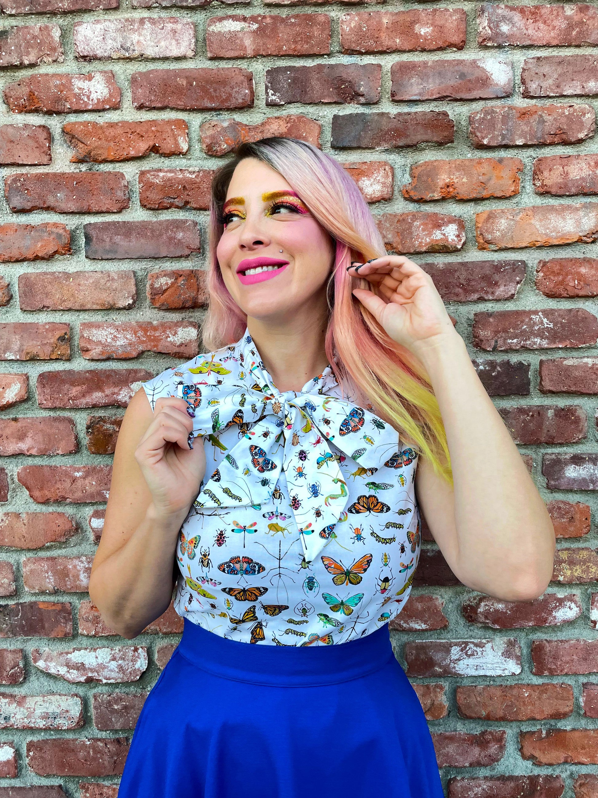 a close up of a model in front of brick wall wearing the royal blue skater skirt