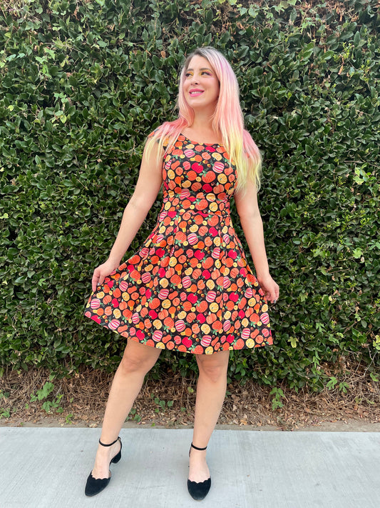 a model standing in front of green shrubs wearing gourdgeous margaret dress