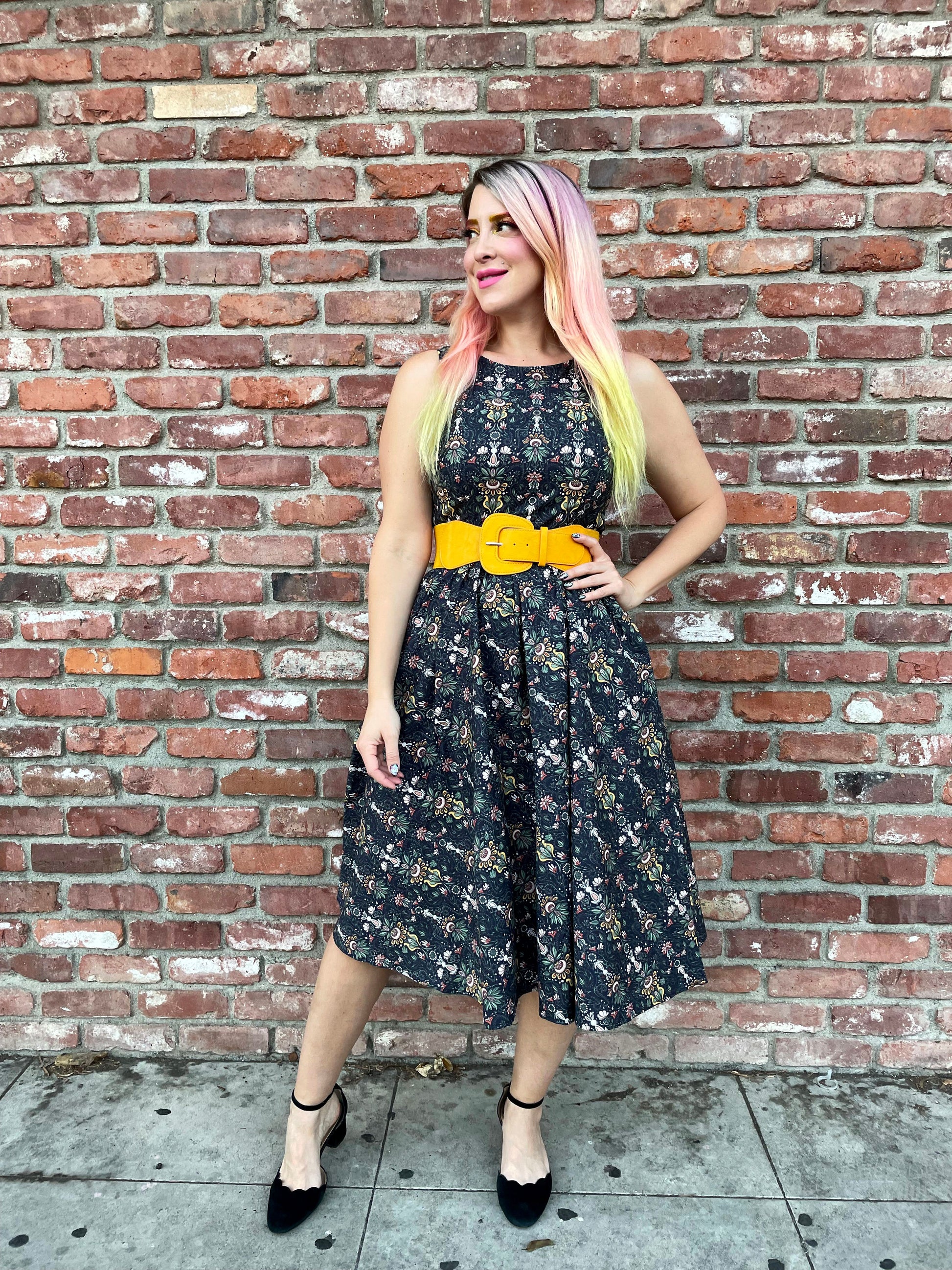 a full length image of a model standing in front of a brick wall wearing the Rabbit Midi dress