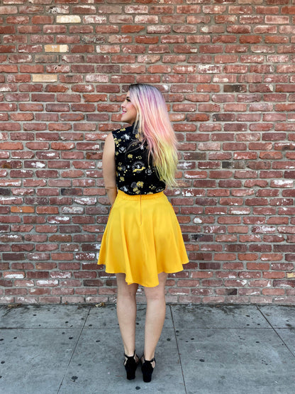 a back view of model in front of brick wall wearing the marigold skater skirt