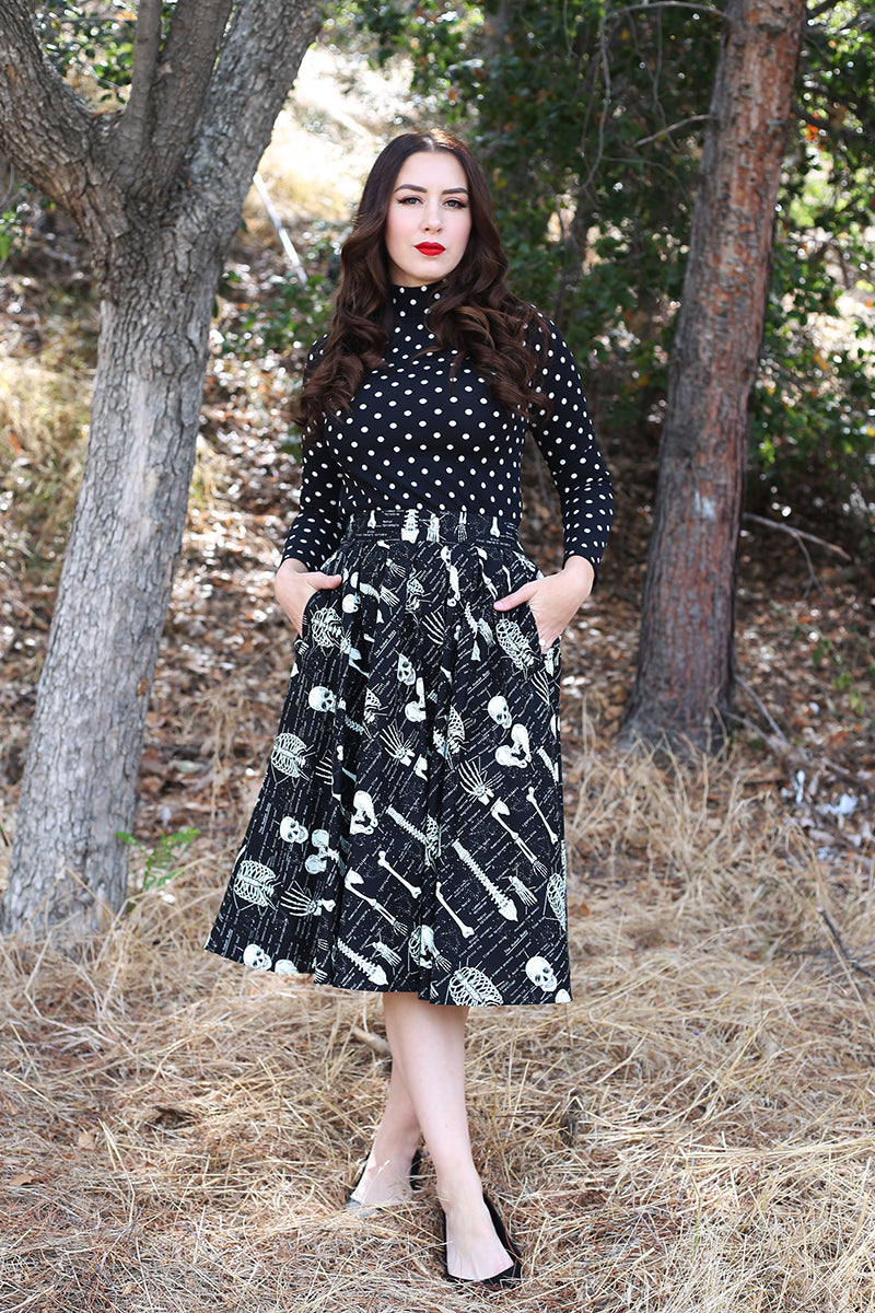 model walking in the forest wearing black polka dot retro top
