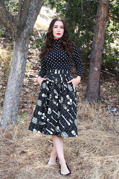 model walking in the forest wearing black polka dot retro top